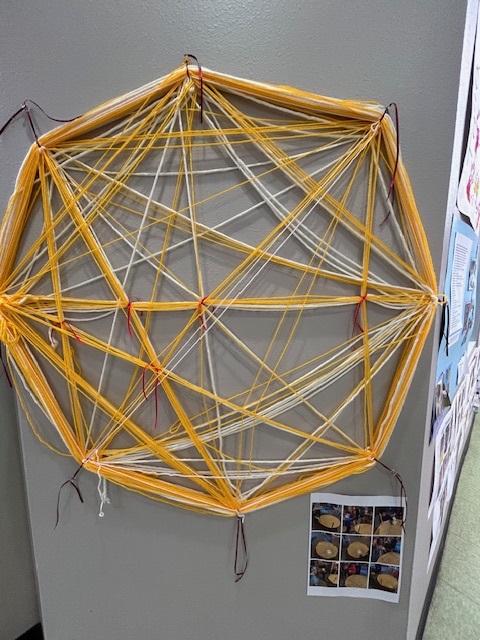 Photo of a child's yellow string art project